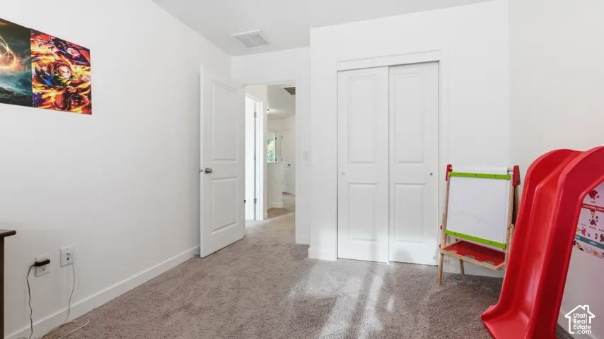Bedroom with sliding closet doors and a doorway leading to the hall.