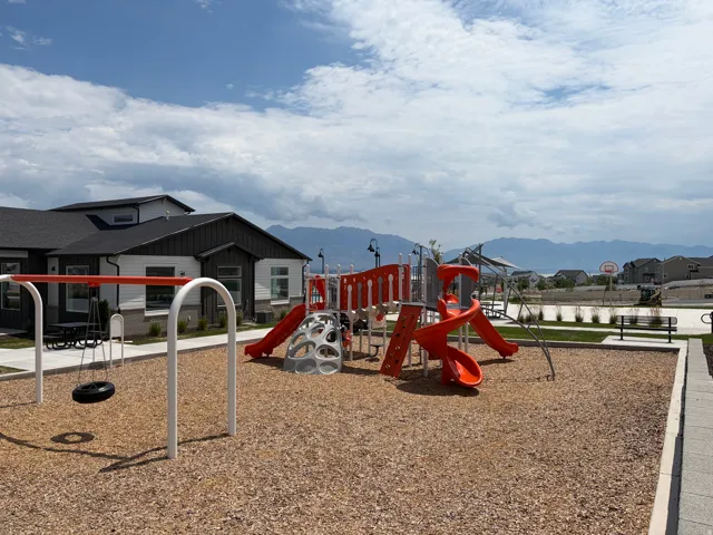 Community playground with multiple slides, swing set, and a basketball hoop
