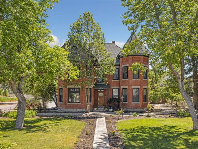Brick exterior featuring a prominent turret with a conical roofline, a gabled entry, and a stone walkway