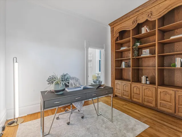 Room featuring extensive built-in wooden shelving with decorative carvings and lower cabinet storage