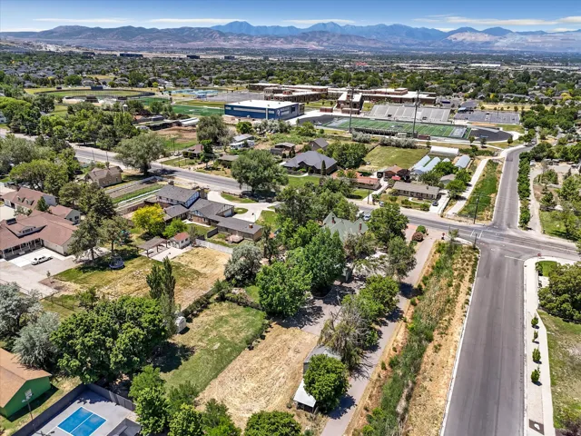 Expansive aerial view of a neighborhood featuring mature trees, residential properties, and paved roadways
