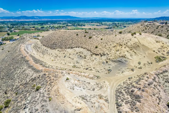 Expansive undeveloped hillside terrain featuring natural vegetation and established dirt roads