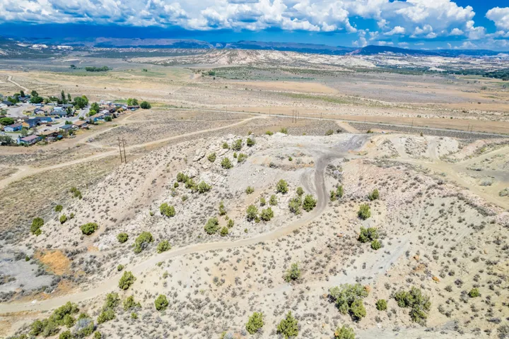 Expansive undeveloped land with natural vegetation, featuring rolling terrain and distant mountain ranges