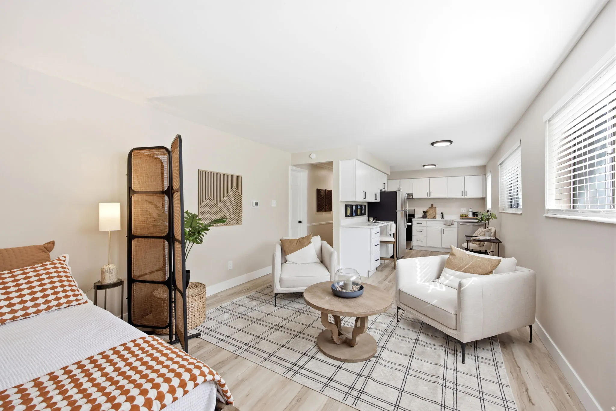 Open-concept living area featuring light wood-finish flooring, white walls, and recessed lighting