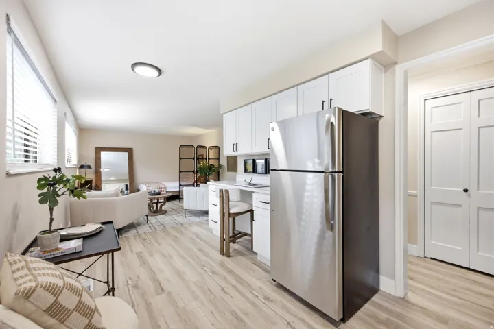 Open-concept living space featuring light wood-finish flooring, white walls, and recessed lighting