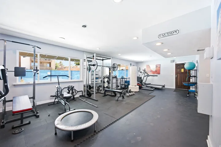 Dedicated fitness room featuring rubberized flooring and expansive windows