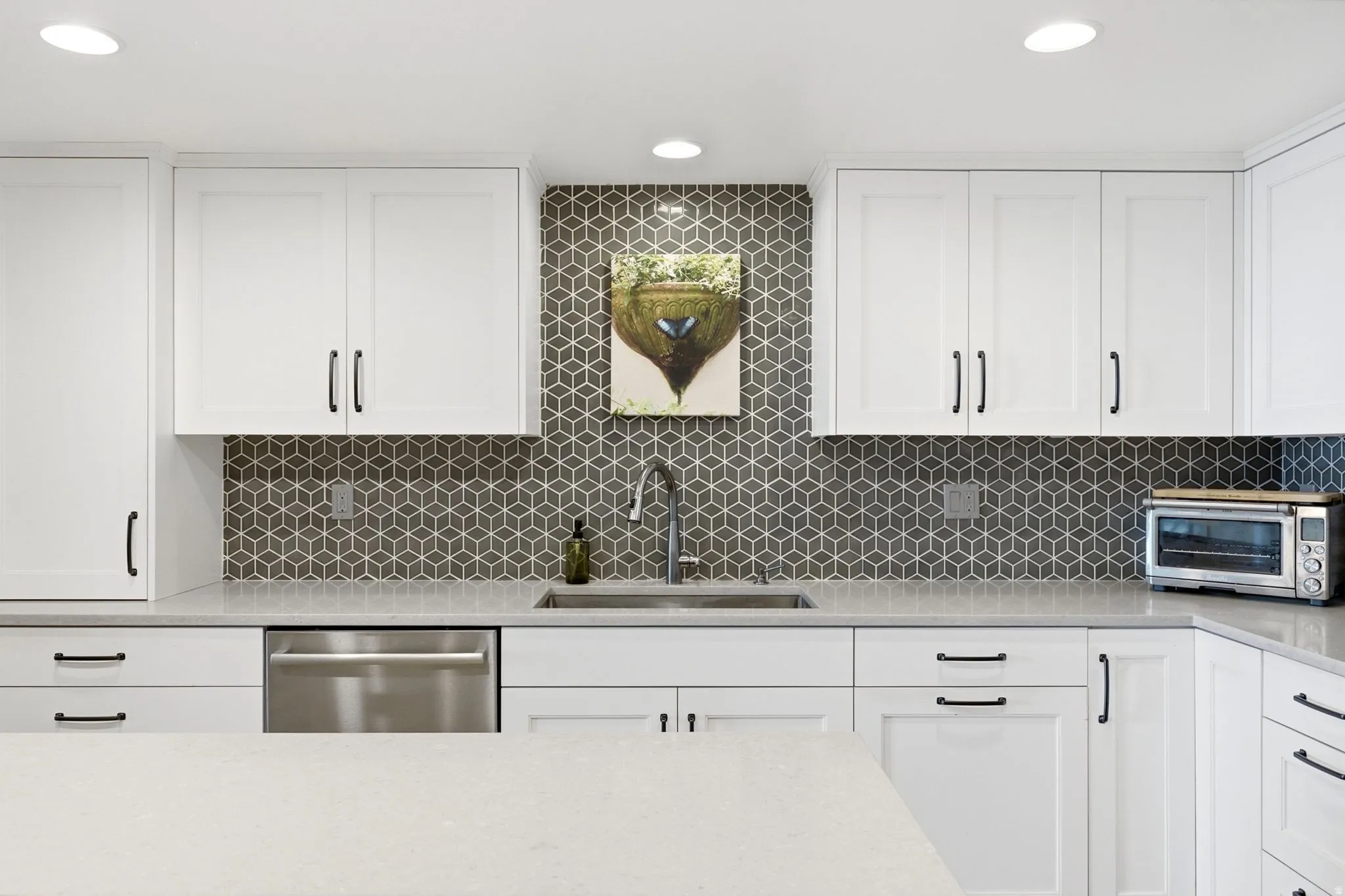 Contemporary kitchen featuring white shaker cabinetry with matte black hardware