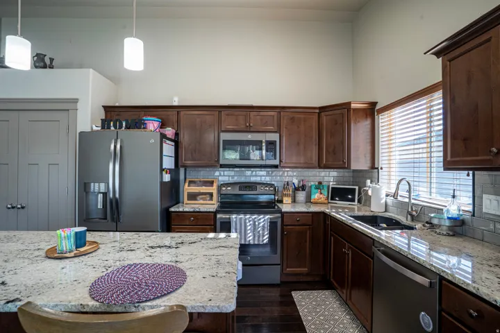 Kitchen featuring dark wood cabinetry, light-toned countertops, and stainless steel appliances