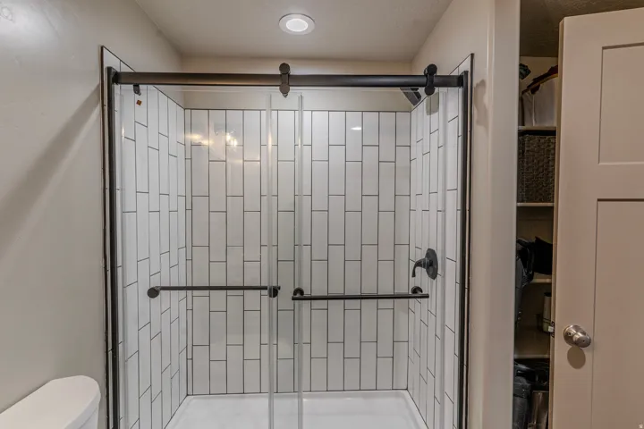Shower enclosure with clear glass sliding doors and matte black hardware