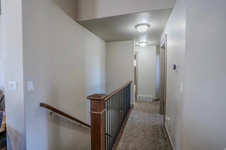 Hallway featuring textured carpeting and flush-mount ceiling lights