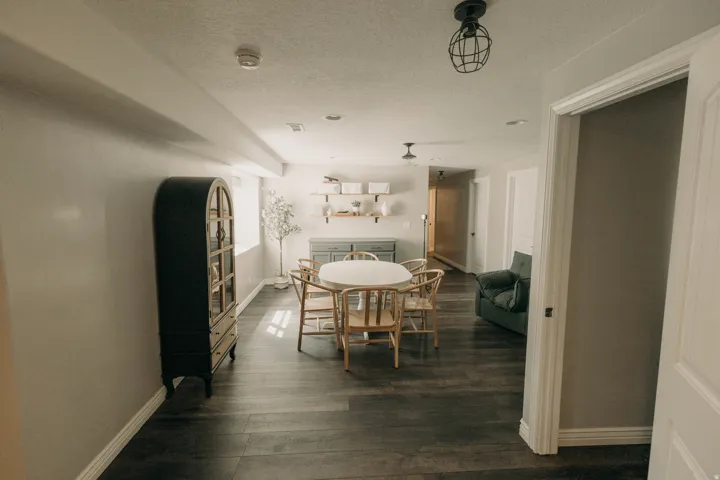 Spacious open-concept room featuring dark wood-finish flooring and light-toned walls