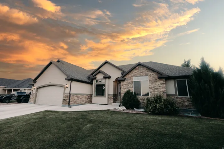 Single-story residence featuring a stone and stucco exterior, an attached two-car garage, and a concrete driveway