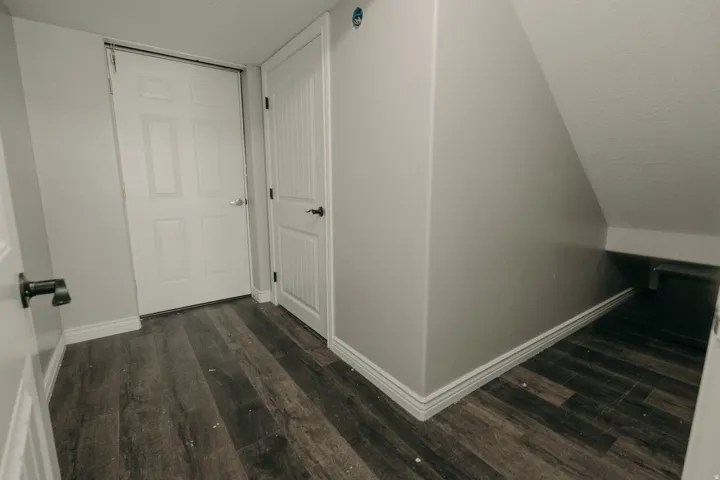 Wood-finish flooring throughout, complemented by white baseboards and neutral wall tones