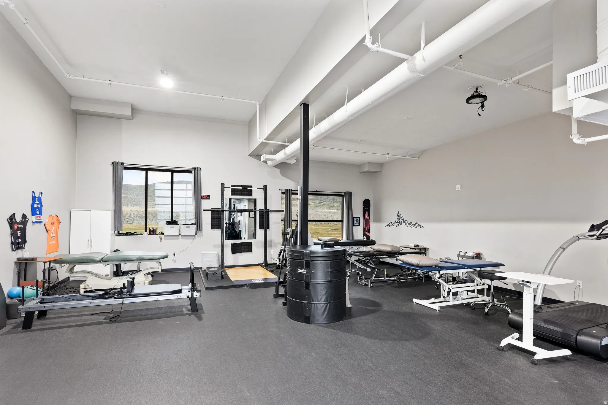 Spacious multi-purpose room featuring neutral walls and dark resilient flooring