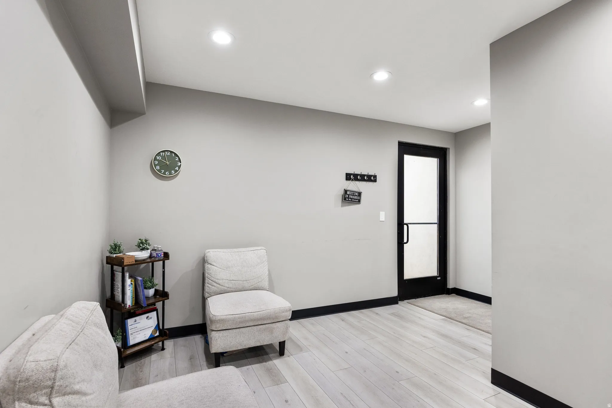 Entryway featuring a black-framed glass panel door, light wood-finish flooring, recessed lighting, and dark baseboards