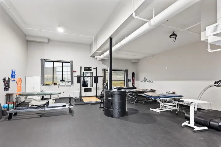 Spacious multi-purpose room featuring neutral walls and dark resilient flooring