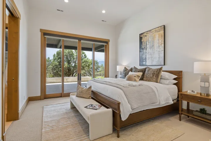 Bedroom featuring expansive glass sliding doors opening to an outdoor patio