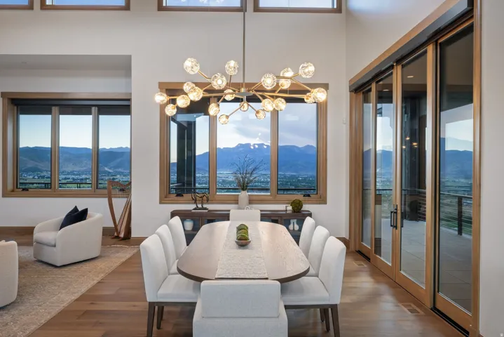 Dining area featuring a contemporary chandelier, wood-finish flooring, and expansive windows