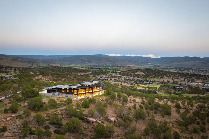 Modern architectural residence with multiple levels, extensive exterior lighting, and large windows