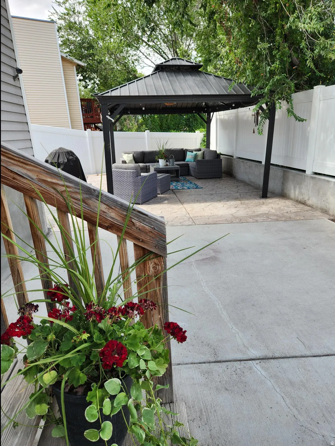 Outdoor patio featuring a black metal gazebo with a tiered roof, providing a dedicated area for outdoor living