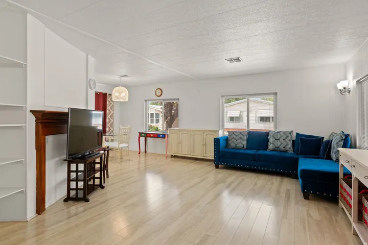 Open living area featuring wood-finish flooring, white walls, and built-in shelving