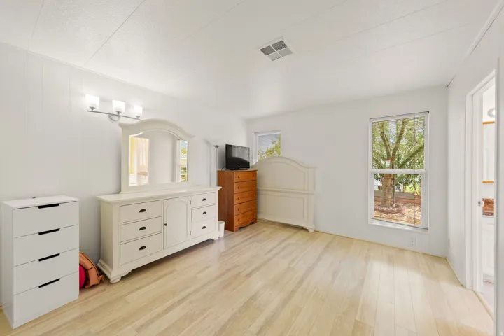 Bright interior space featuring wood-finish flooring, white paneling, and a white textured ceiling