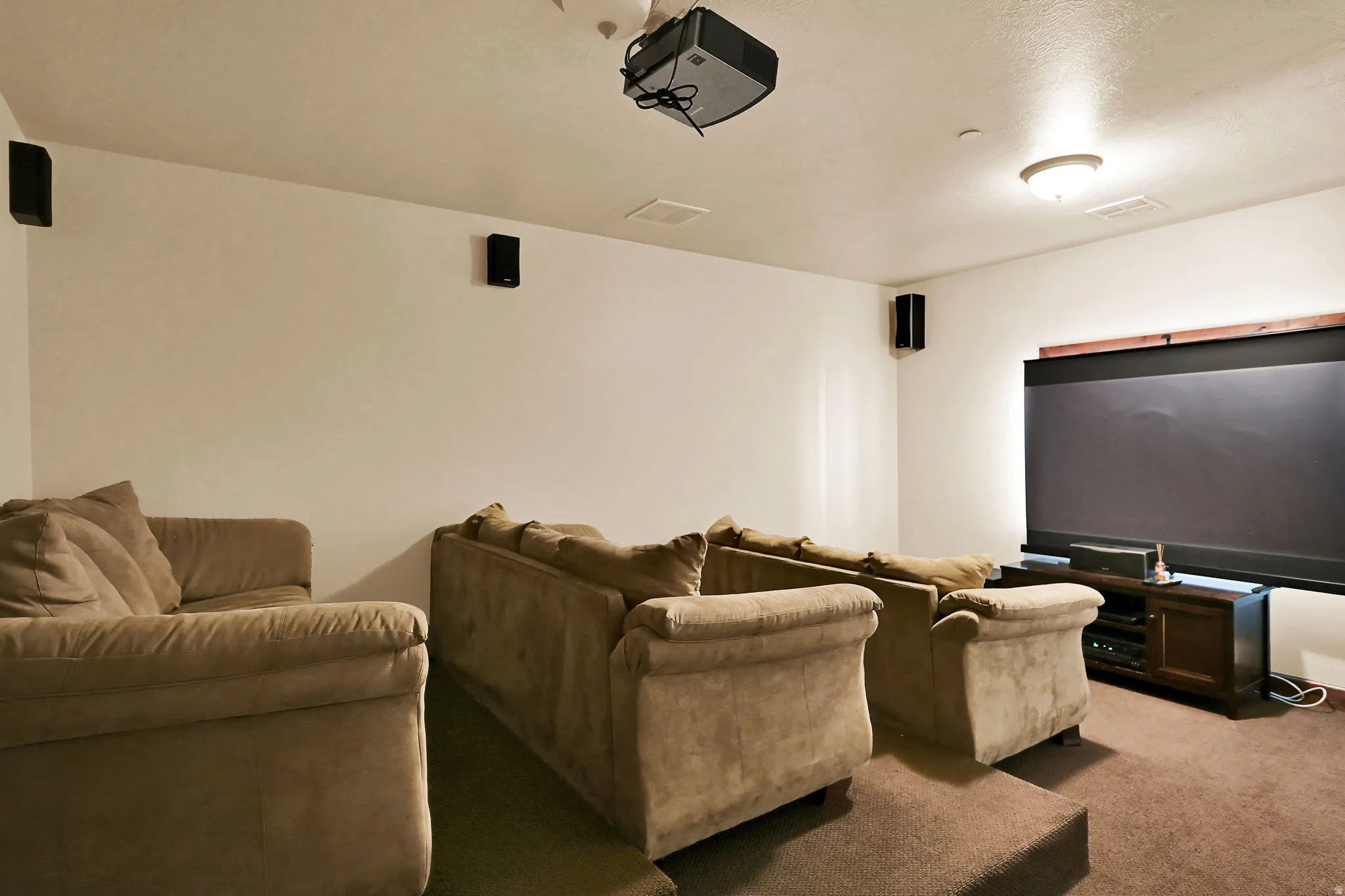 Theater Room on Level P: 300 (Penthouse) Dedicated media room featuring a large projection screen, mounted ceiling projector, and wall-mounted speakers