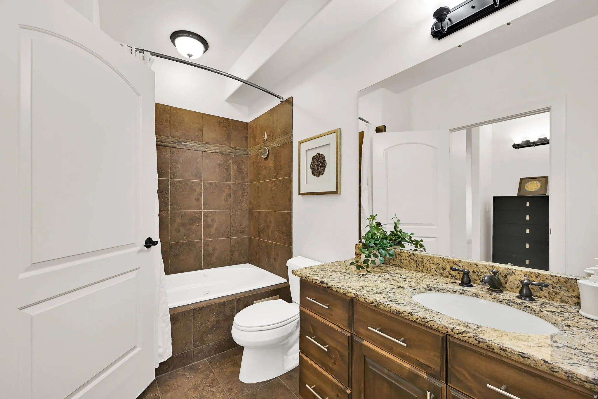 Primary Bathroom featuring a vanity with a granite-style countertop, undermount sink, and dark bronze-finish fixtures