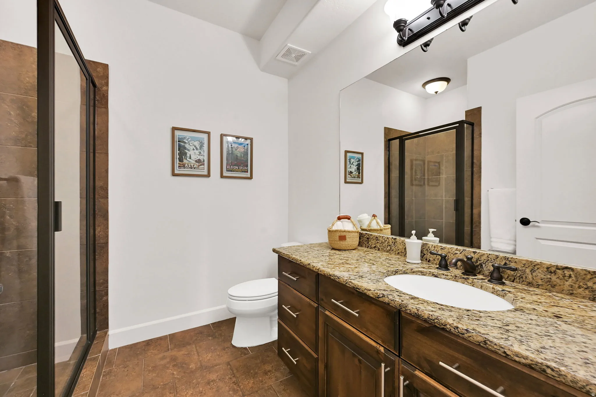 Vanity featuring a granite countertop, an integrated sink, and dark wood cabinetry