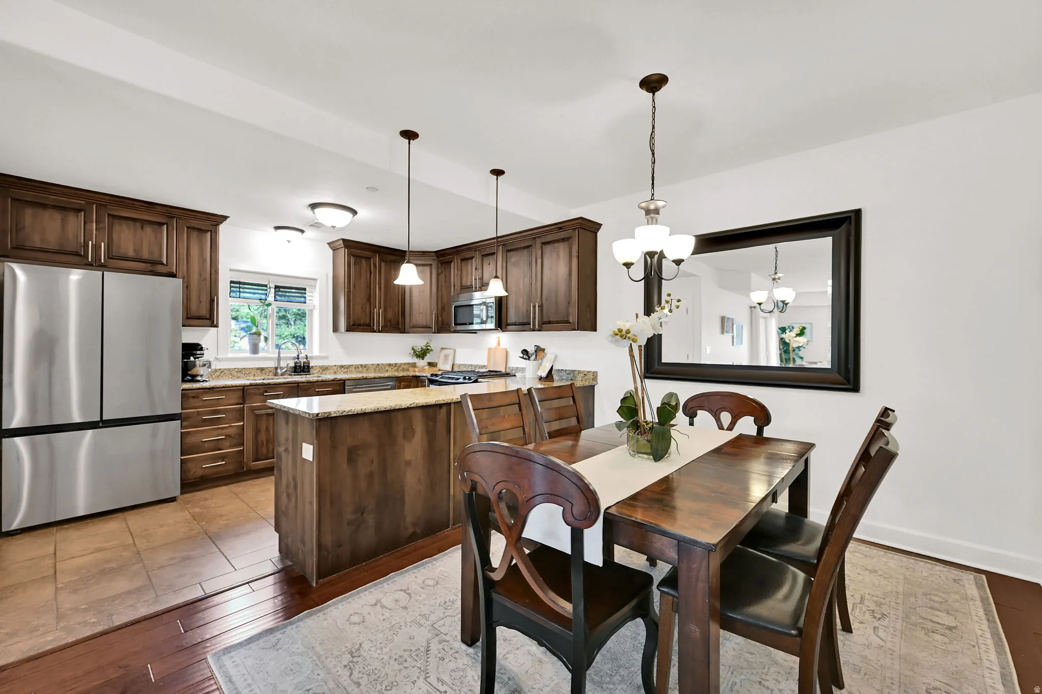 Kitchen and dining area featuring rich wood cabinetry and new stainless steel refrigerator