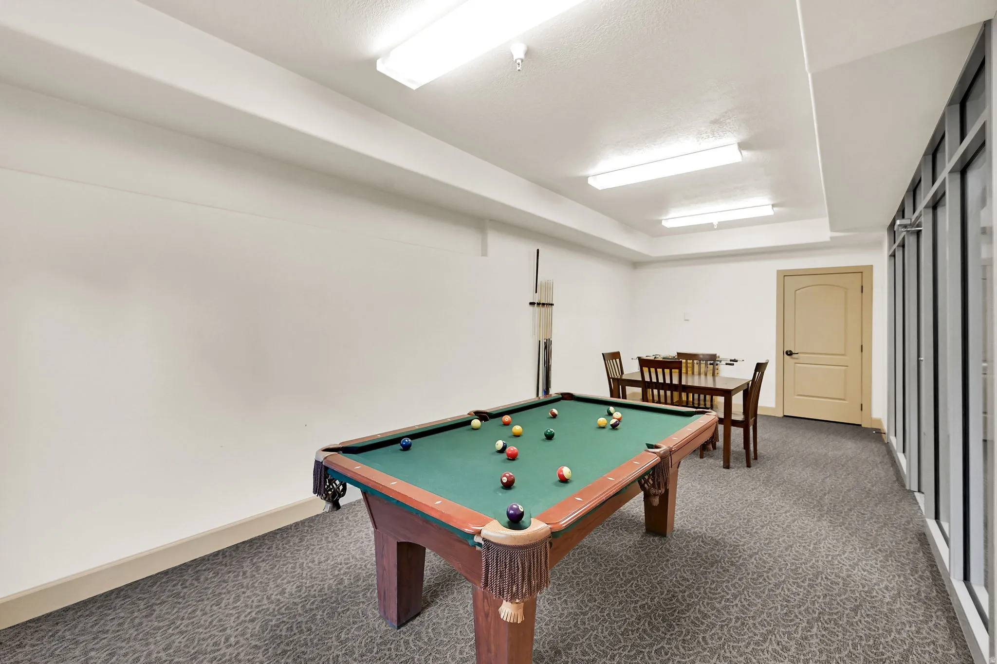 Pool Table on Level G: 10 Level (Ground) Recreation room featuring a billiards table, patterned carpet flooring, a game table with chairs, and a foosball table