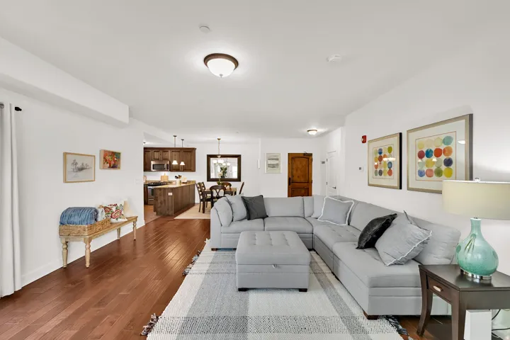 Open-concept living space featuring wood flooring and white walls