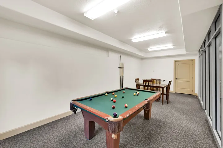 Pool Table on Level G: 10 Level (Ground) Recreation room featuring a billiards table, patterned carpet flooring, a game table with chairs, and a foosball table