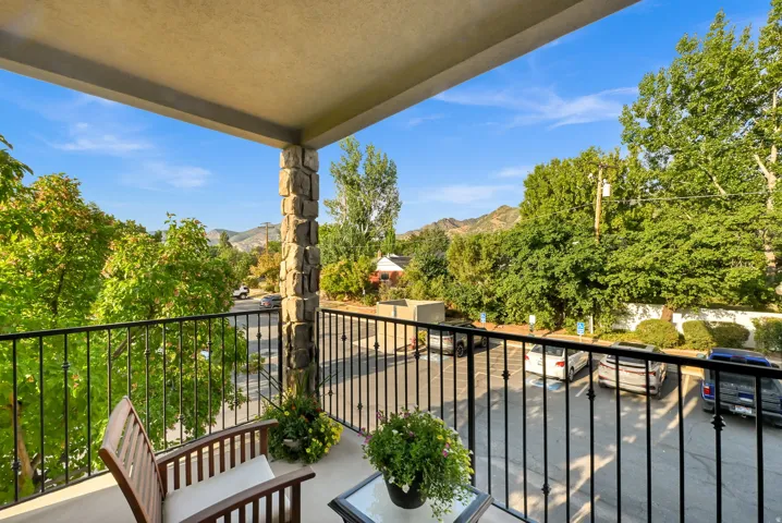 Private outdoor balcony featuring trees and mountain views