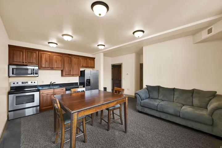 Community Room on Level V: 200 (View) Kitchenette featuring warm wood cabinetry, stainless steel appliances, and dark countertops