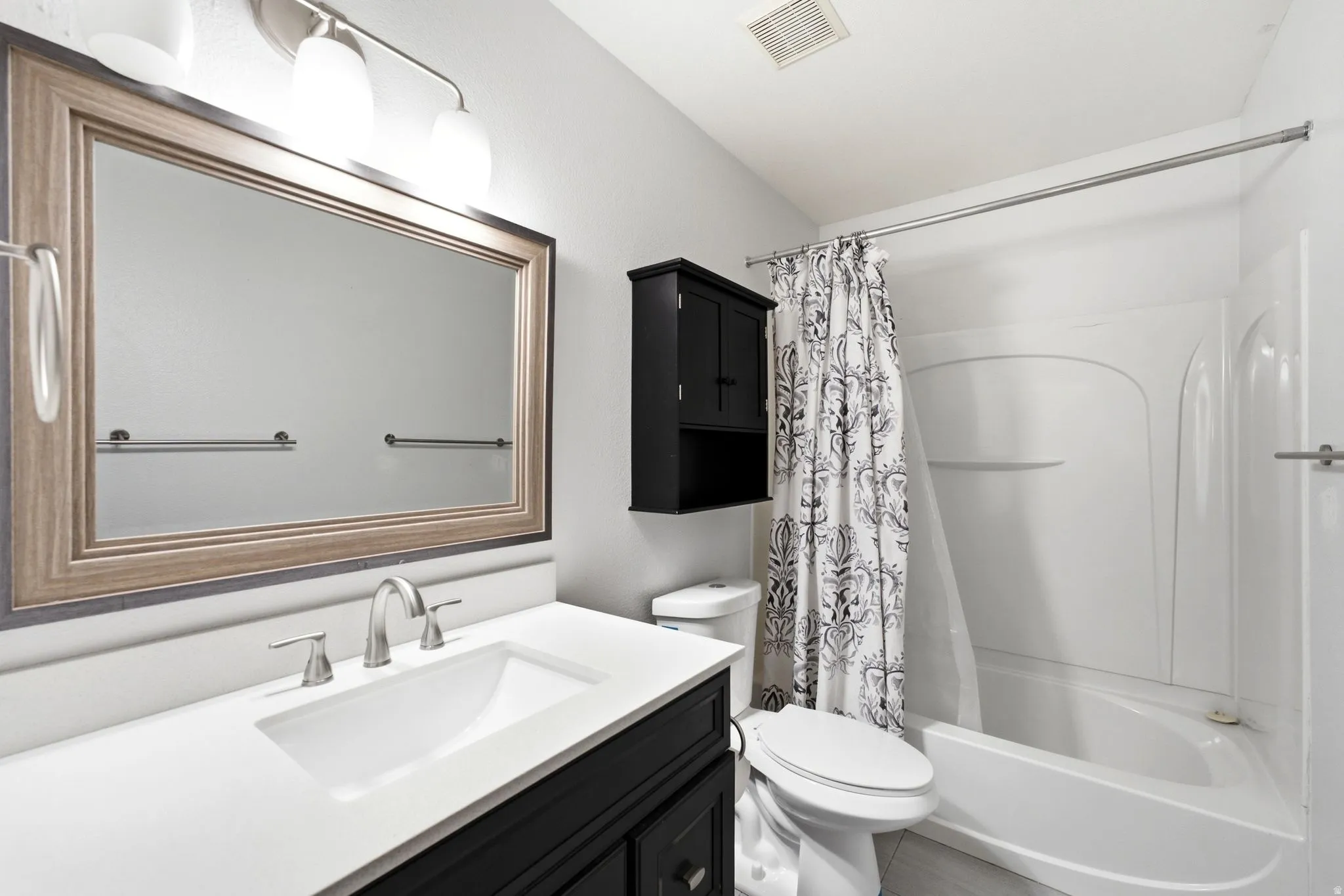 Bathroom with a white vanity featuring a rectangular integrated sink, brushed nickel faucet, and a large framed mirror