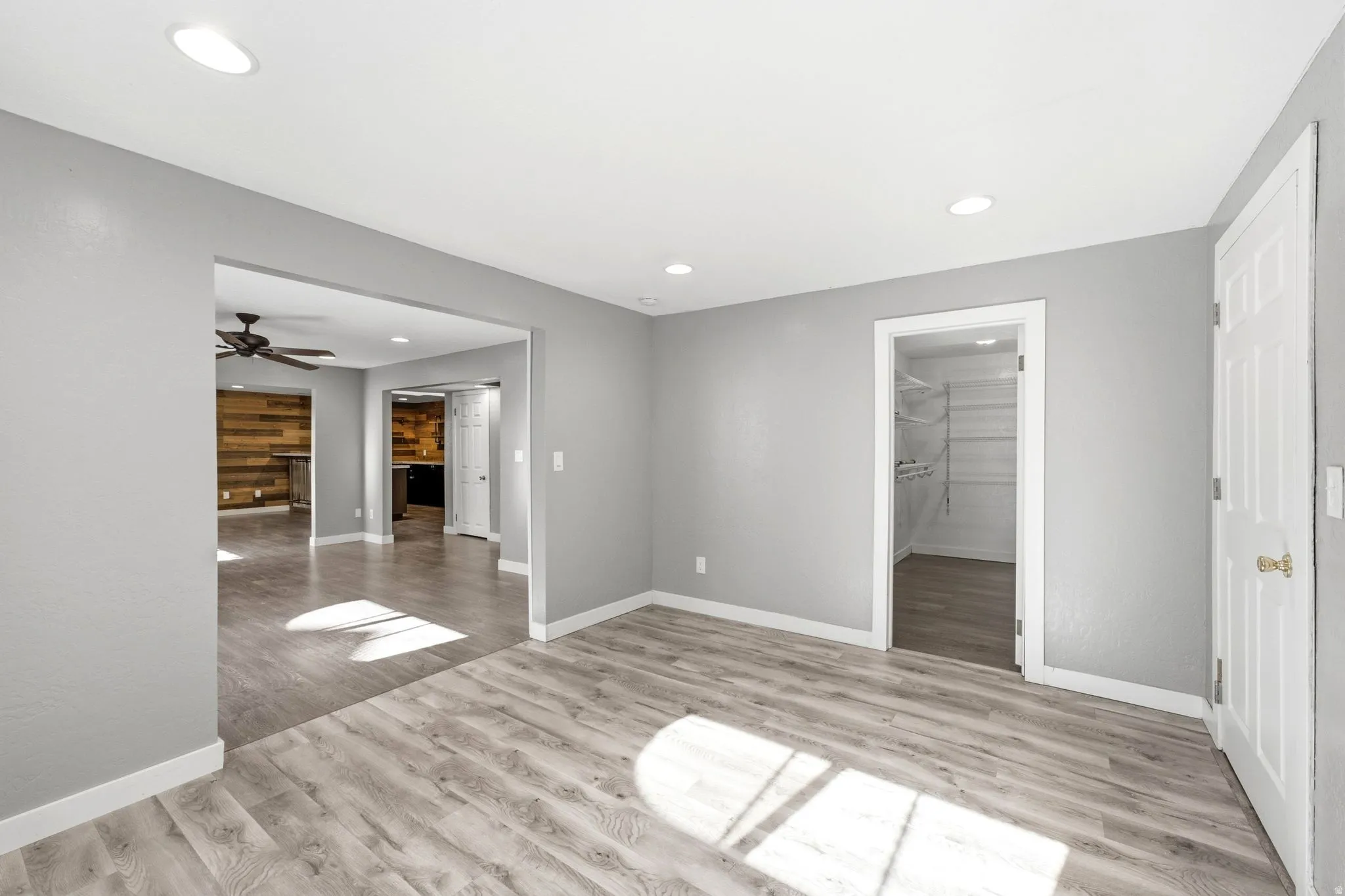 Spacious room featuring wood-finish flooring, recessed lighting, and a neutral wall color