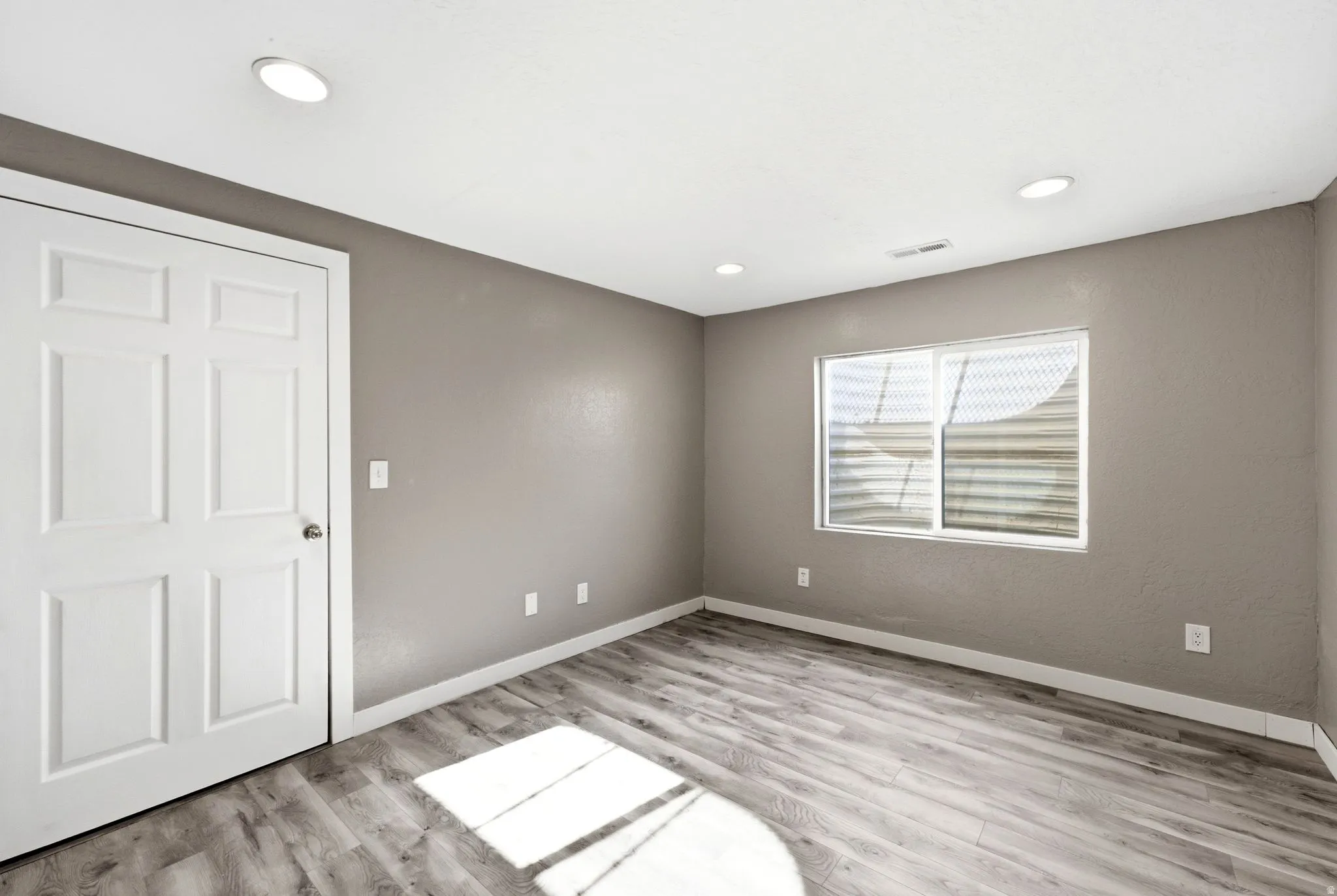 Interior space featuring wood-finish flooring, neutral wall tones, and recessed lighting