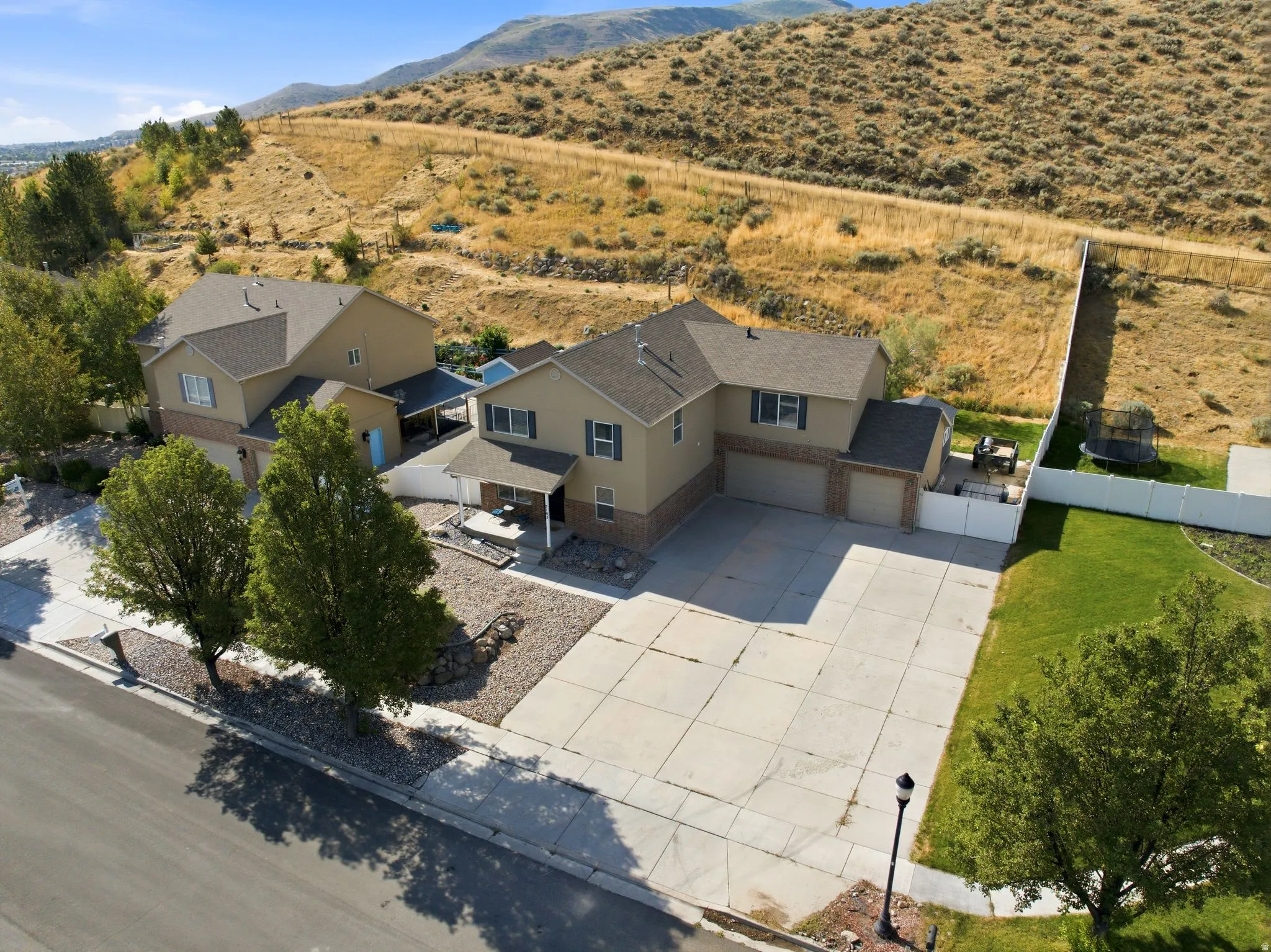 Two-story residence with a beige and brick exterior and a multi-car driveway