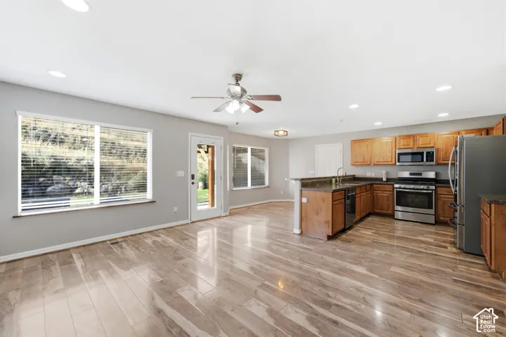 Open-concept living area featuring wood-finish flooring, recessed lighting, and a ceiling fan