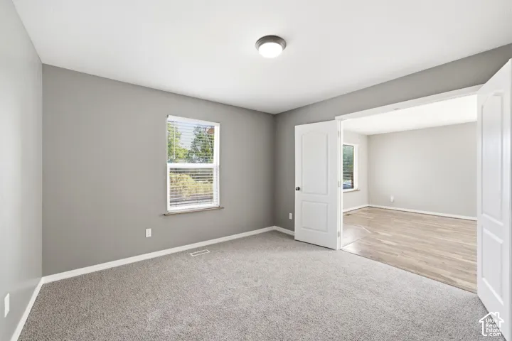 Carpeted room with neutral gray walls and white trim