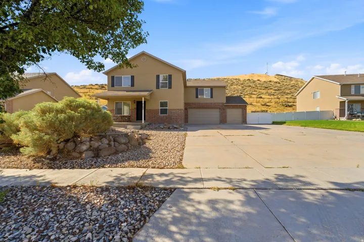 Two-story residence featuring a covered entry, an attached three-car garage, and a concrete driveway