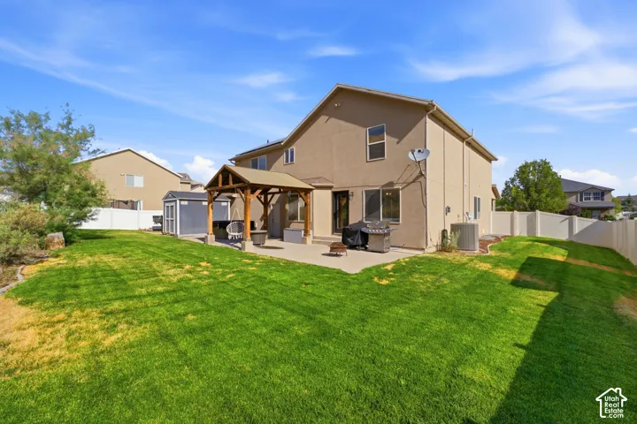 Expansive backyard featuring a manicured lawn, a concrete patio, and a covered pergola