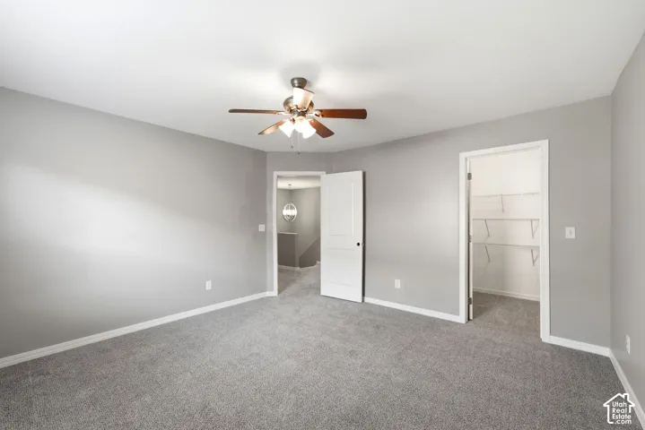 Spacious room featuring neutral grey walls and coordinating grey carpet flooring