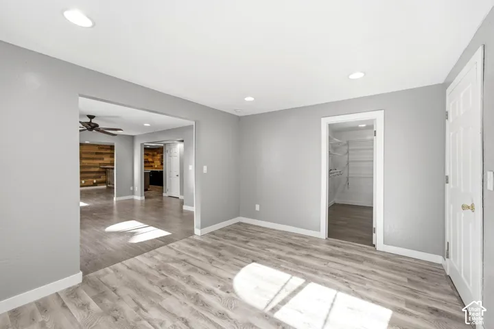 Spacious room featuring wood-finish flooring, recessed lighting, and a neutral wall color