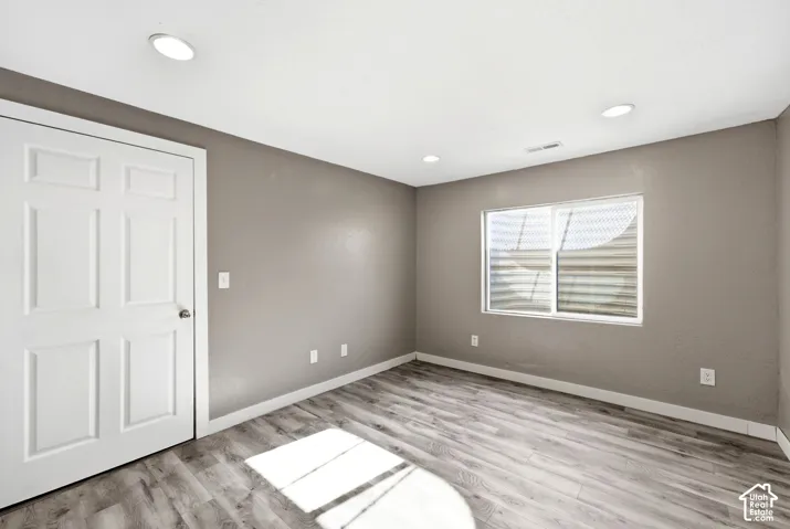 Interior space featuring wood-finish flooring, neutral wall tones, and recessed lighting