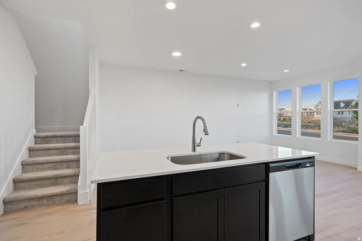 Kitchen island with a stainless steel sink, gooseneck faucet, and integrated dishwasher