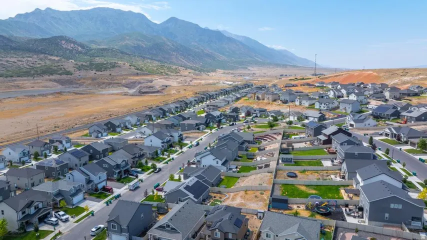 Expansive neighborhood featuring numerous detached homes with gray and light-colored exteriors, asphalt shingle roofs, and some properties with visible solar panels