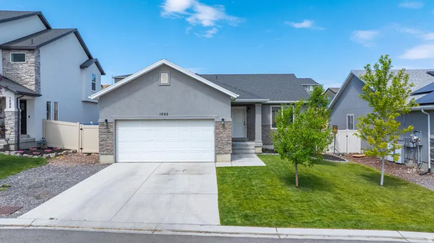 Ranch-style exterior featuring a concrete driveway and an attached two-car garage