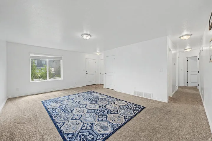Expansive interior space featuring light-colored carpeting and bright white walls